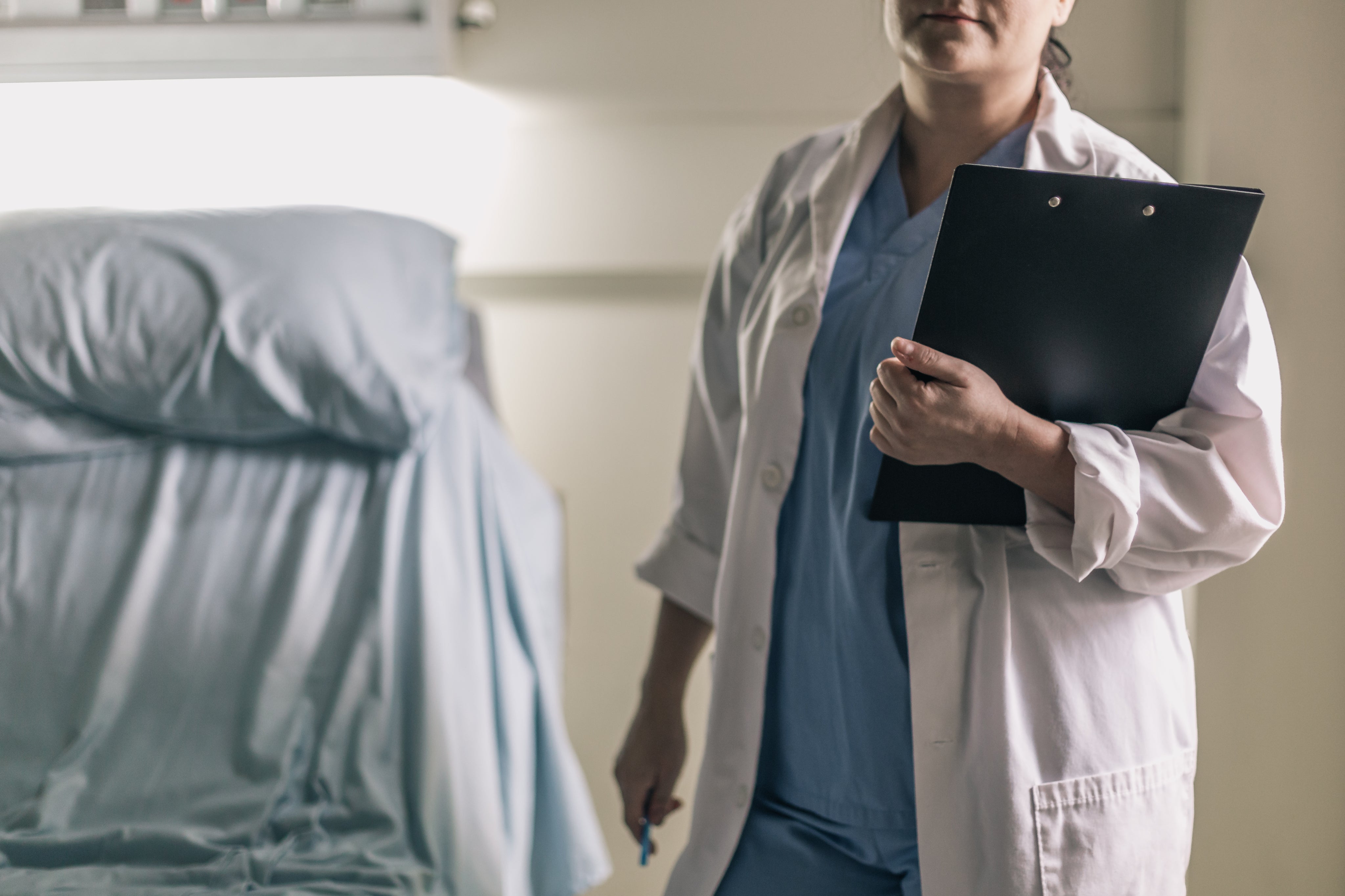 medical-professional-in-scrubs-holding-clipboard-and-pen.jpg